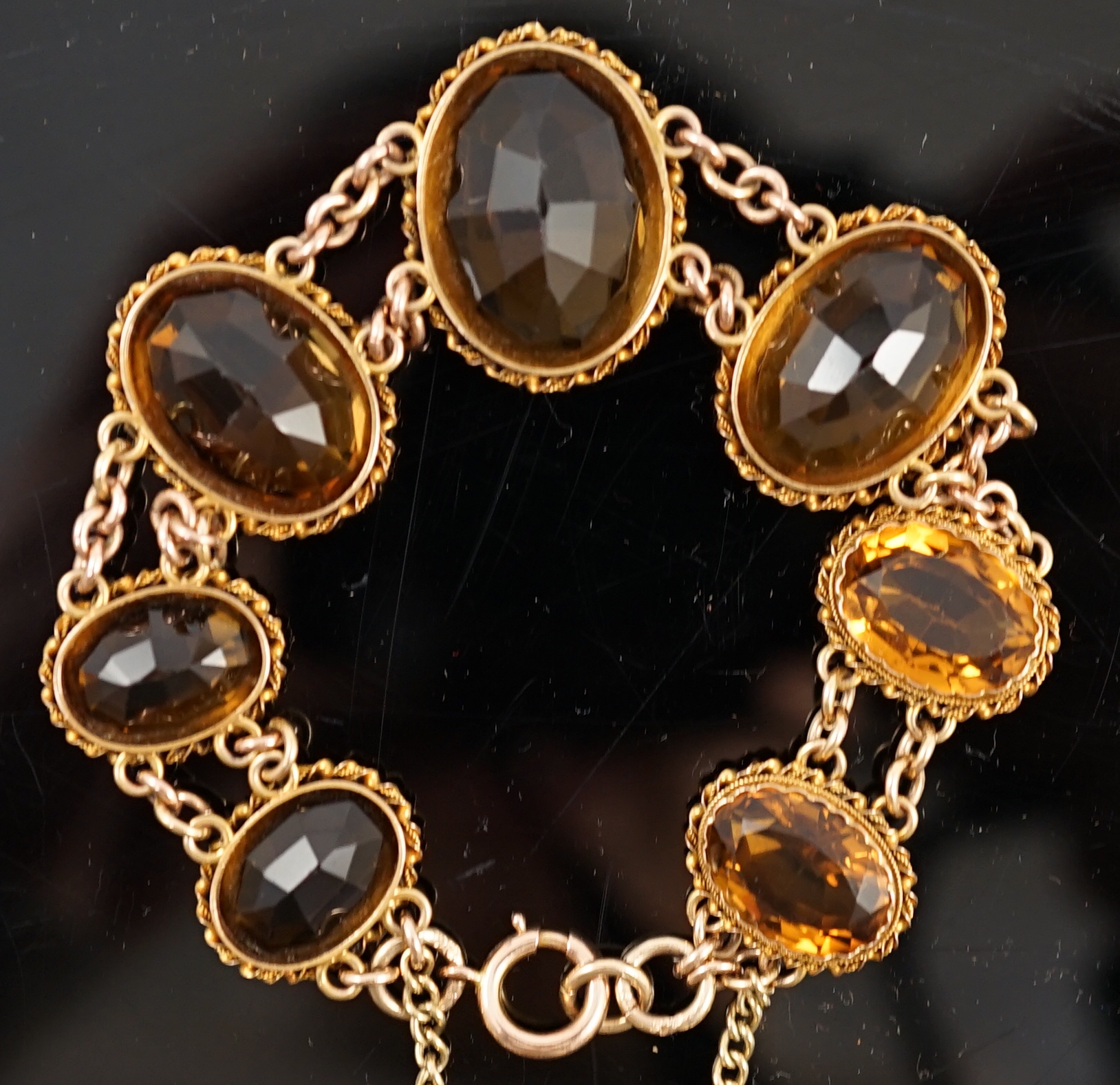 An early 20th century 9ct gold and graduated seven stone oval cut citrine set bracelet